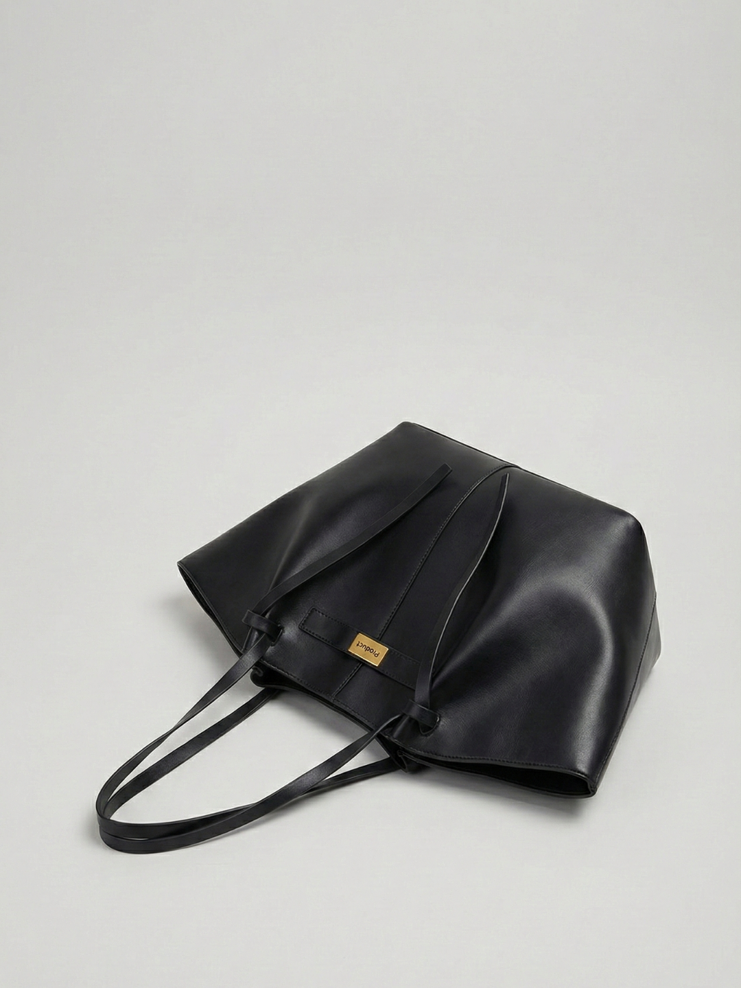 Black leather bag with a visible brand label on a light gray background