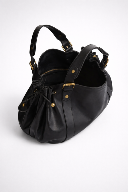 Black leather handbag with gold accents on a white background