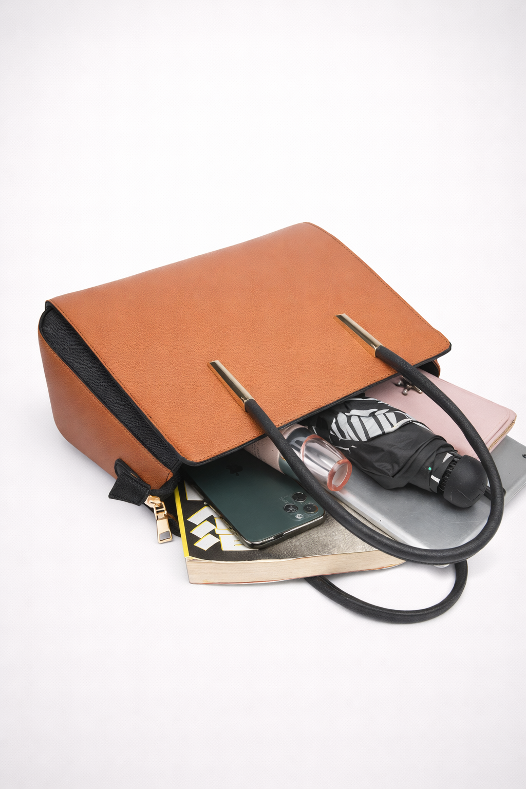 Brown leather handbag with black strap on a white background