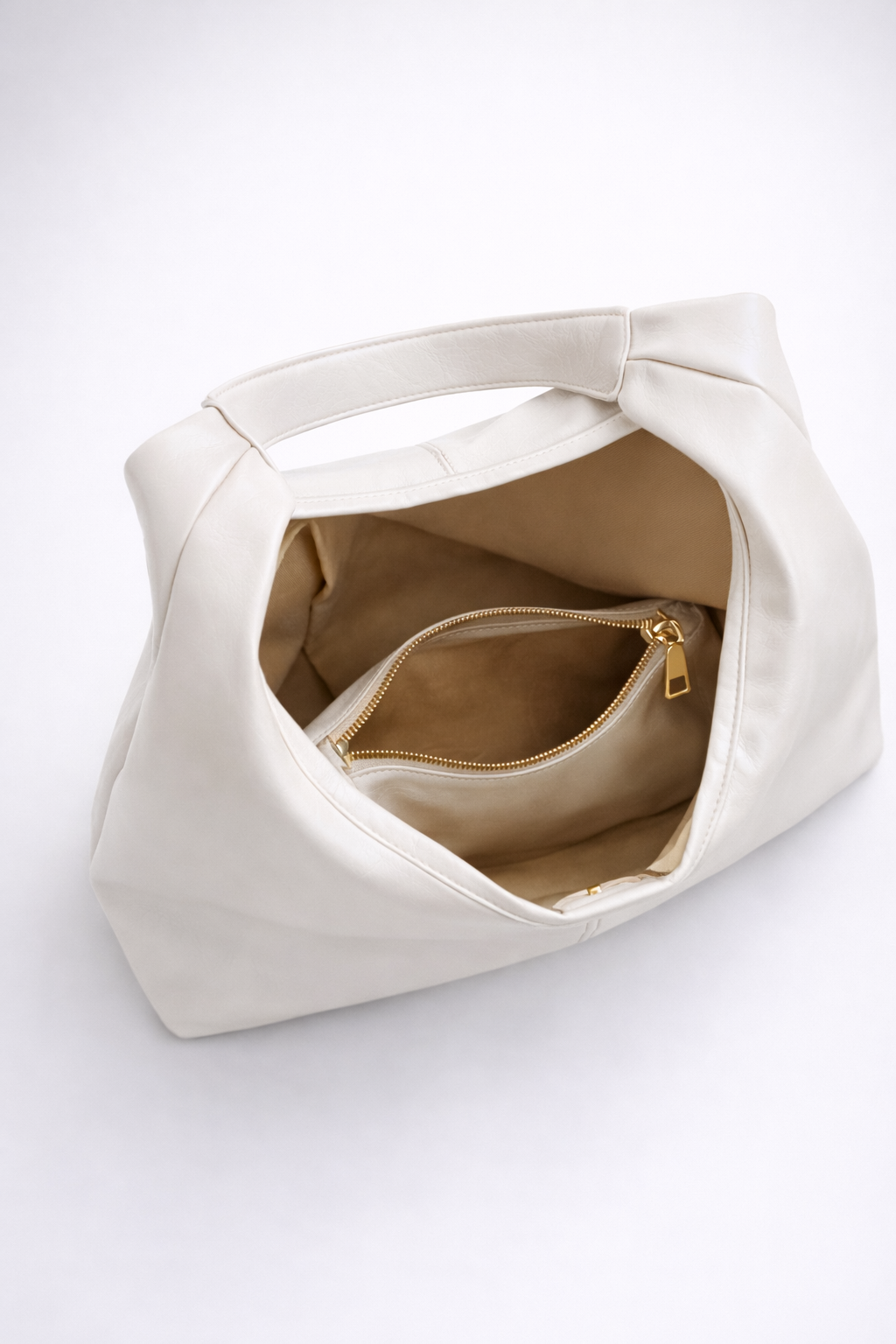 White handbag with a gold zipper on a white background