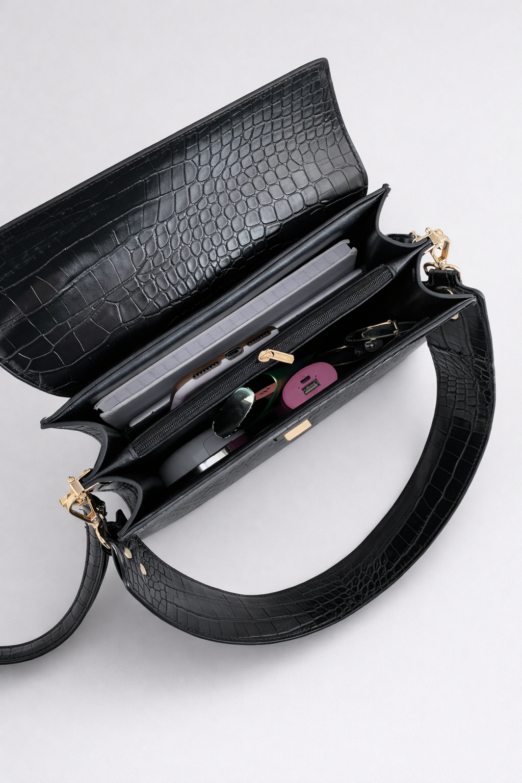 Black crocodile-patterned handbag on a light gray background